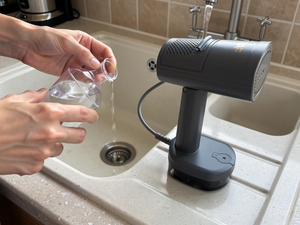 Filling the clear tank at the tap with the water cup
